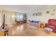 Living room with hardwood floors, featuring a sofa, window and access to the balcony at 1900 59Th N Ave # 305, St Petersburg, FL 33714