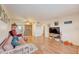 Living room with hardwood floors, featuring a sofa, TV, and access to the kitchen at 1900 59Th N Ave # 305, St Petersburg, FL 33714