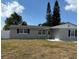 Newly renovated house featuring gray brick exterior, and a well-manicured lawn at 2643 Almond Dr, Holiday, FL 34691