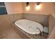 Relaxing bathtub with jacuzzi jets and deck, surrounded by decorative tile and soft lighting at 2918 10Th N St, St Petersburg, FL 33704