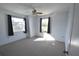 Bright bedroom featuring neutral carpet, ceiling fan and two windows with dark curtains at 2918 10Th N St, St Petersburg, FL 33704