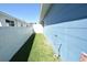 Narrow side yard featuring green grass between a blue home and white fence at 2918 10Th N St, St Petersburg, FL 33704