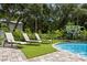 Three lounge chairs are situated on a paver patio next to the pool at 7877 98Th St, Seminole, FL 33777