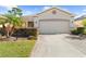 Tan house with two-car garage and landscaping at 1028 Orca Ct, Holiday, FL 34691