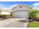 Tan house with two-car garage and landscaping at 1028 Orca Ct, Holiday, FL 34691