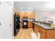 Well-equipped kitchen featuring black appliances and light wood cabinets at 1028 Orca Ct, Holiday, FL 34691