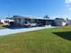 Single-wide mobile home with carport and covered patio at 164 Colonial Ct # 19, Palm Harbor, FL 34684