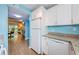 White kitchen with stainless steel appliances and view of living room at 211 S Mcmullen Booth Rd # 189, Clearwater, FL 33759