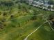 Aerial view of a green golf course with winding paths at 3647 Muirfield Ct, New Port Richey, FL 34655