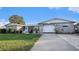 Single-story home with gray stone exterior and a white garage door at 3706 Bigelow Dr, Holiday, FL 34691