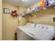 Convenient laundry room with washer, dryer, and ample storage shelves at 1651 Sand Key Estates Ct # 52, Clearwater, FL 33767