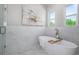 Relaxing bathroom with a freestanding soaking tub and marble tile at 3845 Seena Manor Ct, Tampa, FL 33618
