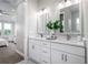 Double vanity bathroom with white cabinets, quartz countertops, and large mirrors at 3845 Seena Manor Ct, Tampa, FL 33618