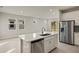 Kitchen island with a sink, dishwasher and a view into the living area at 20345 Symphony Pl, Venice, FL 34293