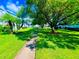 Landscaped community lawn with mature trees and a paved walkway at 2060 Marilyn St # 239, Clearwater, FL 33765