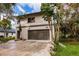 Modern two-story house with a large garage and landscaped yard at 21048 Peachland Blvd, Port Charlotte, FL 33954