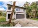 Modern two-story house with a large garage and landscaped yard at 21048 Peachland Blvd, Port Charlotte, FL 33954