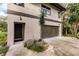 Modern garage with dark brown door and landscaping at 21048 Peachland Blvd, Port Charlotte, FL 33954