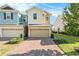 Two-story townhome with tan and teal exterior, two-car garage, and landscaping at 6330 Camino Dr, Apollo Beach, FL 33572