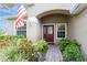 Inviting front entry with a brick walkway, lush landscaping and a red door at 1433 Emerald Hill Way, Valrico, FL 33594