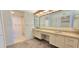 Bathroom featuring double sinks, large mirror, and neutral-toned finishes at 3076 Eastland Blvd # 106, Clearwater, FL 33761