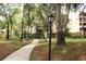 Picturesque community grounds with walking path, mature trees, and manicured landscaping at 3076 Eastland Blvd # 106, Clearwater, FL 33761