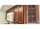 Kitchen features wooden cabinets, a white microwave and a glass cabinet for storage at 3076 Eastland Blvd # 106, Clearwater, FL 33761