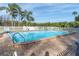 Inviting community pool with brick patio and palm trees at 9000 Commodore Dr # 401, Seminole, FL 33776