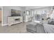 Bright living room with herringbone floors, comfy seating, and access to a balcony at 9000 Commodore Dr # 401, Seminole, FL 33776