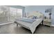 Bright bedroom with a king-size bed, herringbone floors, and large windows at 9000 Commodore Dr # 401, Seminole, FL 33776