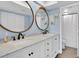 Double vanity bathroom with marble countertop and large mirrors at 9000 Commodore Dr # 401, Seminole, FL 33776
