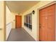 Apartment building hallway with an orange door and exit at 9000 Commodore Dr # 401, Seminole, FL 33776