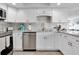 Well-equipped kitchen with white cabinets, marble counters, and stylish backsplash at 9000 Commodore Dr # 401, Seminole, FL 33776
