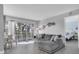 Spacious living room with gray sectional sofa and access to a balcony at 9000 Commodore Dr # 401, Seminole, FL 33776