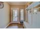 Bright entryway with tiled floors, white bench and storage at 94 The Cove Way, Indian Rocks Beach, FL 33785