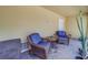 Covered patio with wicker chairs and small table at 94 The Cove Way, Indian Rocks Beach, FL 33785