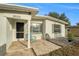 House exterior featuring a front yard, driveway and teal chair at 15133 Harding Ave, Clearwater, FL 33760