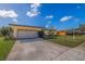 Ranch style home with attached garage and lawn at 1585 Idle Dr, Clearwater, FL 33756