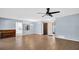 Open living room with wood-look floors and access to kitchen and patio at 3499 Cedar Ln, Palm Harbor, FL 34684