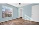 Bright bedroom featuring hardwood floors, a large window, and a convenient walk-in closet at 3499 Cedar Ln, Palm Harbor, FL 34684