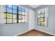 Bright bedroom featuring wood flooring, two large windows, and neutral-colored walls at 3499 Cedar Ln, Palm Harbor, FL 34684