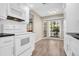 Well-lit kitchen with modern appliances, white cabinetry, and a bright window overlooking the garden at 3499 Cedar Ln, Palm Harbor, FL 34684