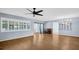 Expansive living room with hardwood floors, piano, and large windows allowing ample sunlight at 3499 Cedar Ln, Palm Harbor, FL 34684