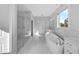 Spa-like bathroom with soaking tub, walk-in shower, and marble floors at 3612 W Renellie Cir, Tampa, FL 33629