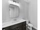 Modern bathroom with dark vanity, marble countertop and a frameless mirror at 3612 W Renellie Cir, Tampa, FL 33629