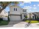 Two-story house with light gray siding, a two-car garage, and a landscaped front yard at 3612 W Renellie Cir, Tampa, FL 33629