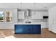 Modern kitchen with white cabinets, blue island, and stainless steel appliances at 3612 W Renellie Cir, Tampa, FL 33629