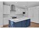 Modern kitchen with white cabinets, blue island, and stainless steel appliances at 3612 W Renellie Cir, Tampa, FL 33629