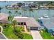 Beautiful aerial view of waterfront home showcasing lush landscaping, a modern garage door, and brick driveway at 11683 Grove St, Seminole, FL 33772