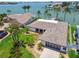 Beautiful aerial view of waterfront home showcasing lush landscaping, a modern garage door, and brick driveway at 11683 Grove St, Seminole, FL 33772